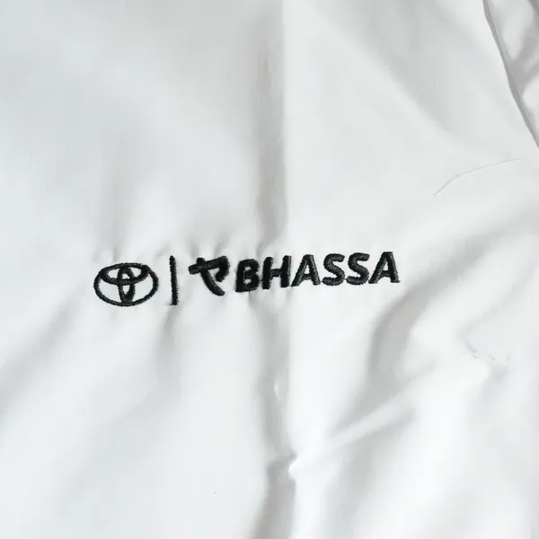 Camisa blanca con logos de Toyota y Bhassa bordados en negro